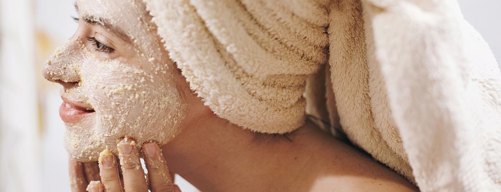Woman exfoliating face